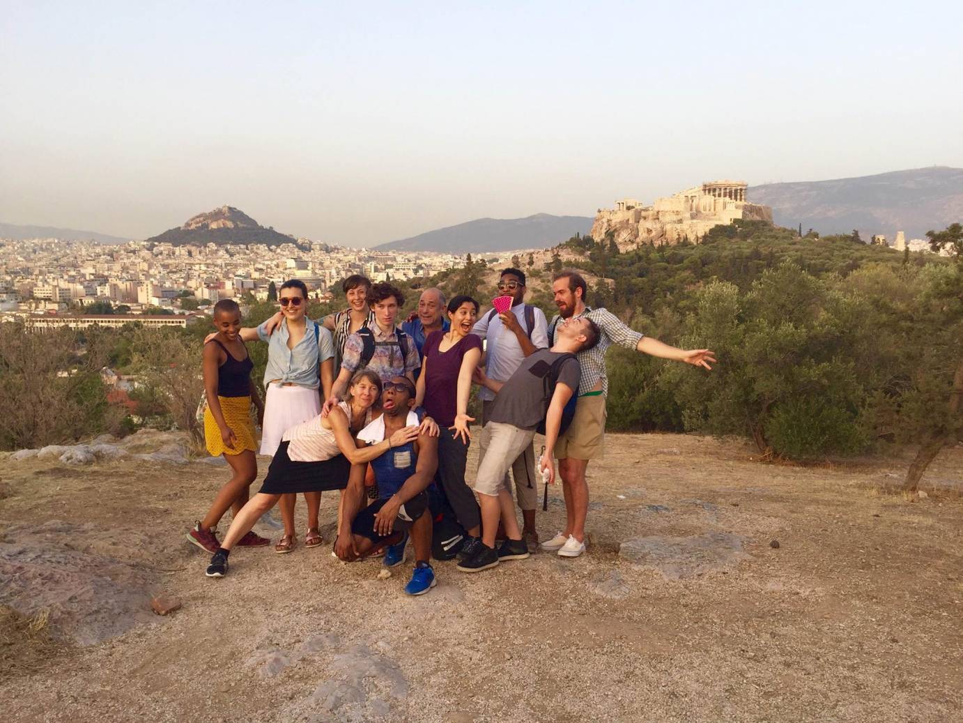 Company members strike silly faces for a photo overlooking the city of Athens